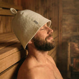 Man wearing a traditional natural wool sauna hat for balanced heat protection in a sauna
