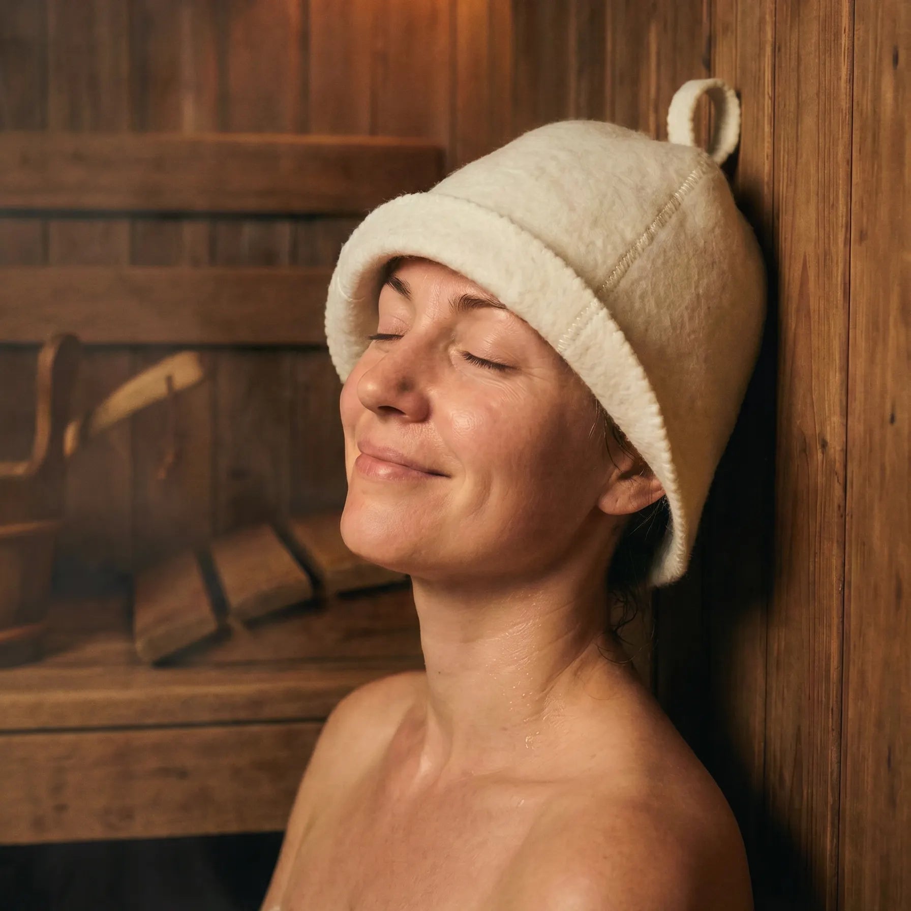 Woman relaxing in a traditional sauna while wearing an extra thick wool sauna hat